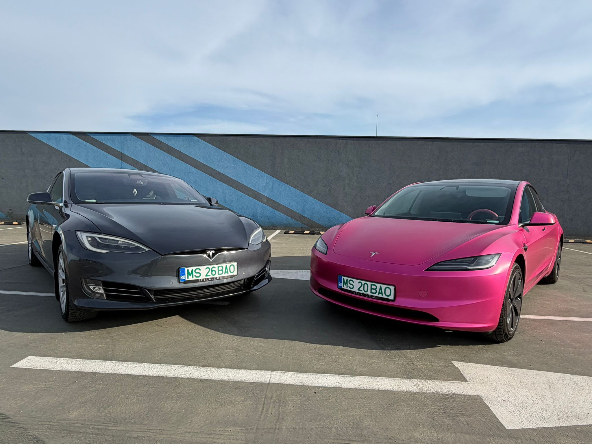 Both Teslas together — the pink Model 3 and dark Model S